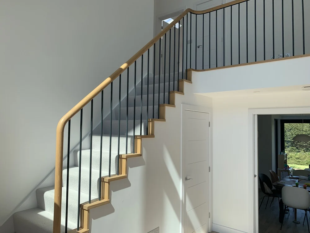Curved oak handrail with metal spindles