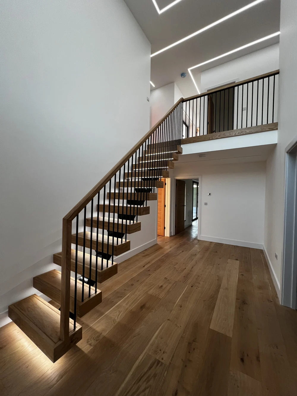 Steel spine staircase with oak treads and metal spindles