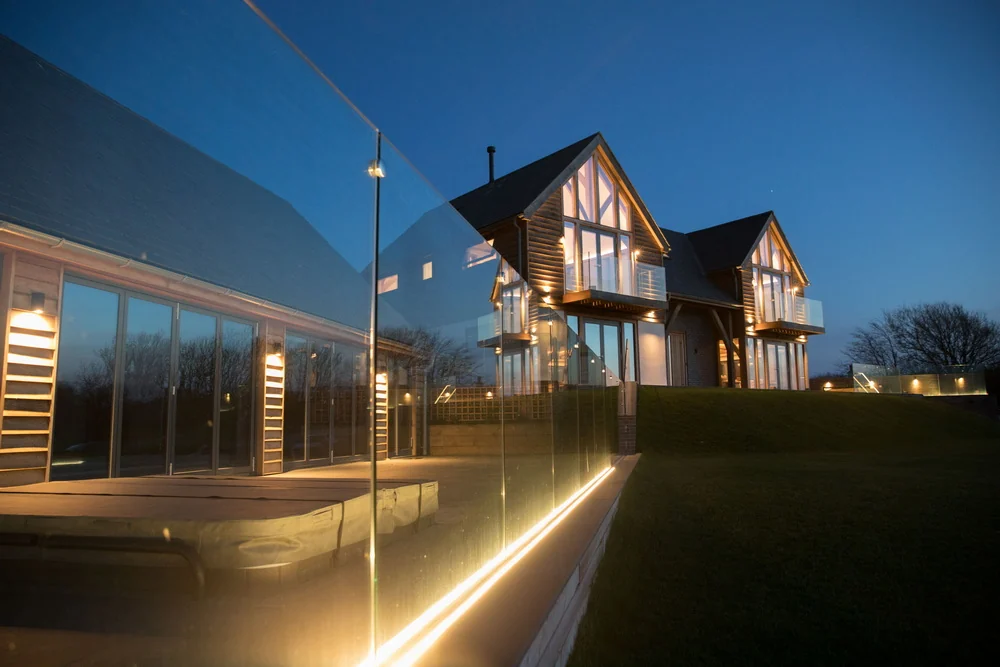 Green oak-framed new build with glass balustrade