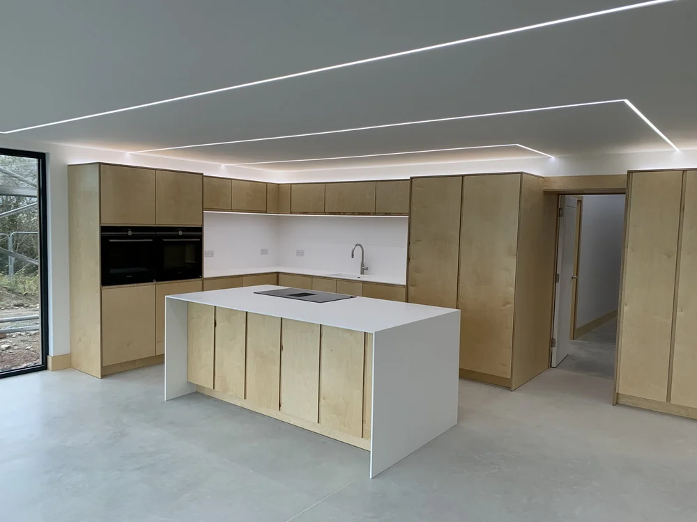 Plywood kitchen with polished concrete floor and LED lighting
